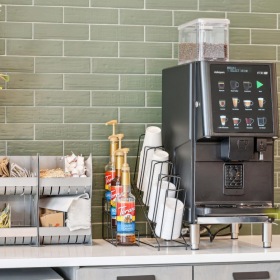 Cutting-edge amenities at your fingertips coffee bar with a plant next to it on the counter